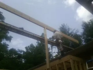 Carpenter setting a ridge beam over a new addition frame — Ice Dam Removal by Roofing Brothers in Newton Falls