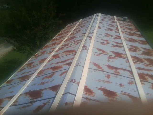 Rusted metal roof panels with new wood purlins before replacement — Storm Damage Roof Repair in Newton Falls by Roofing Brothers
