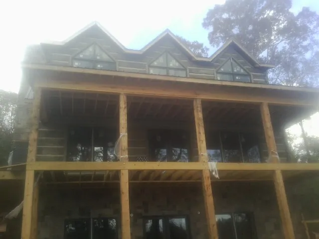 Dormers and porch framing on a large log home under construction — Roof Coating work by our crew in Newton Falls